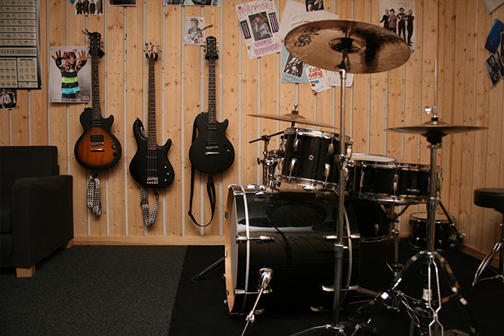 Replokal med gitarrer och affischer på väggarna