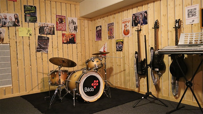 Replokal med gitarrer och affischer på väggarna