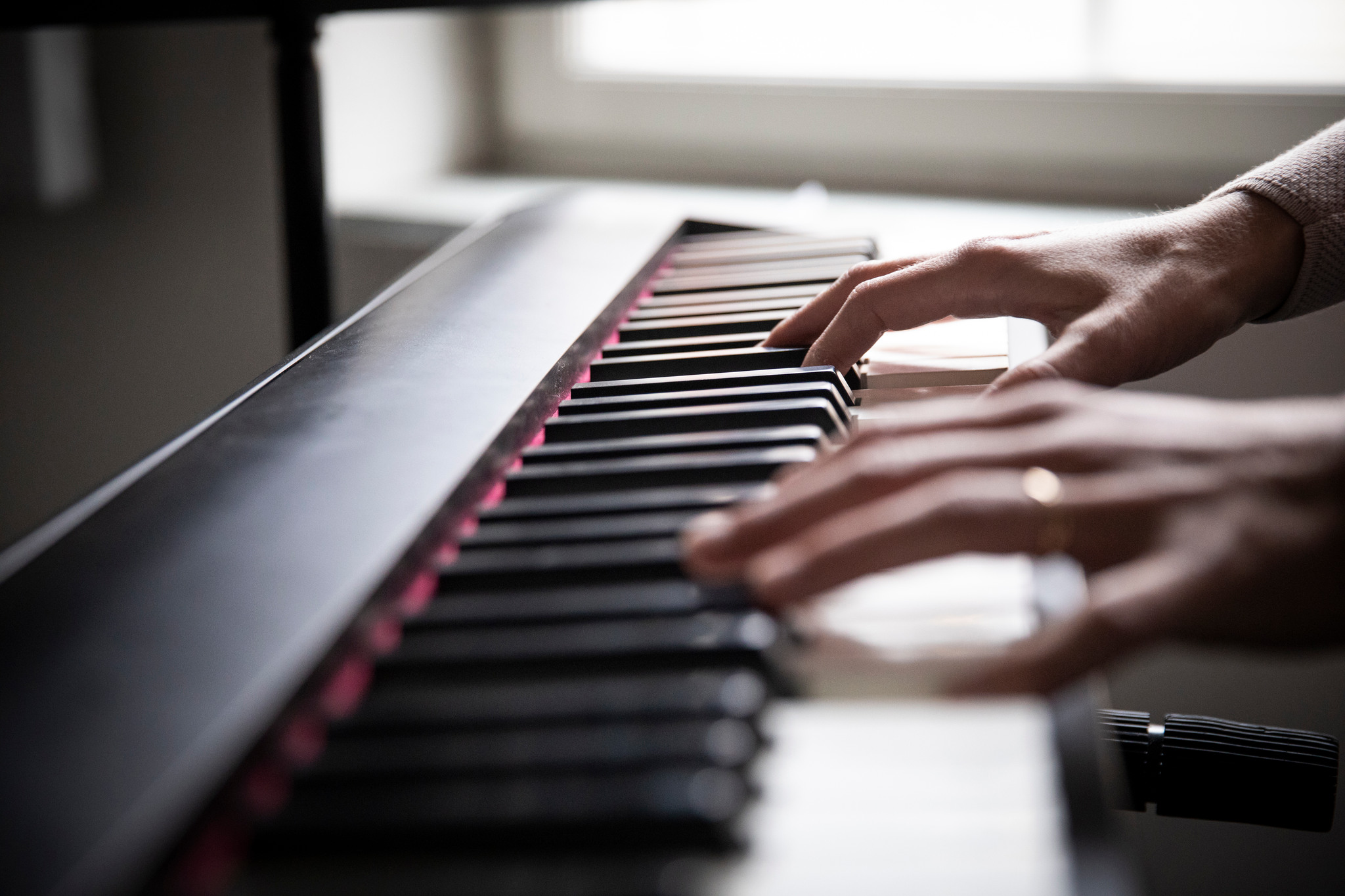 Händer som spelar på ett elpiano