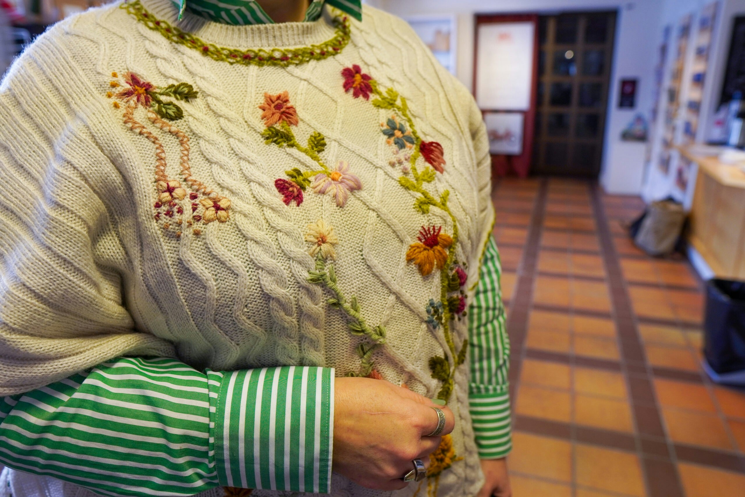 en kvinna som bär en tröja med blommor på.