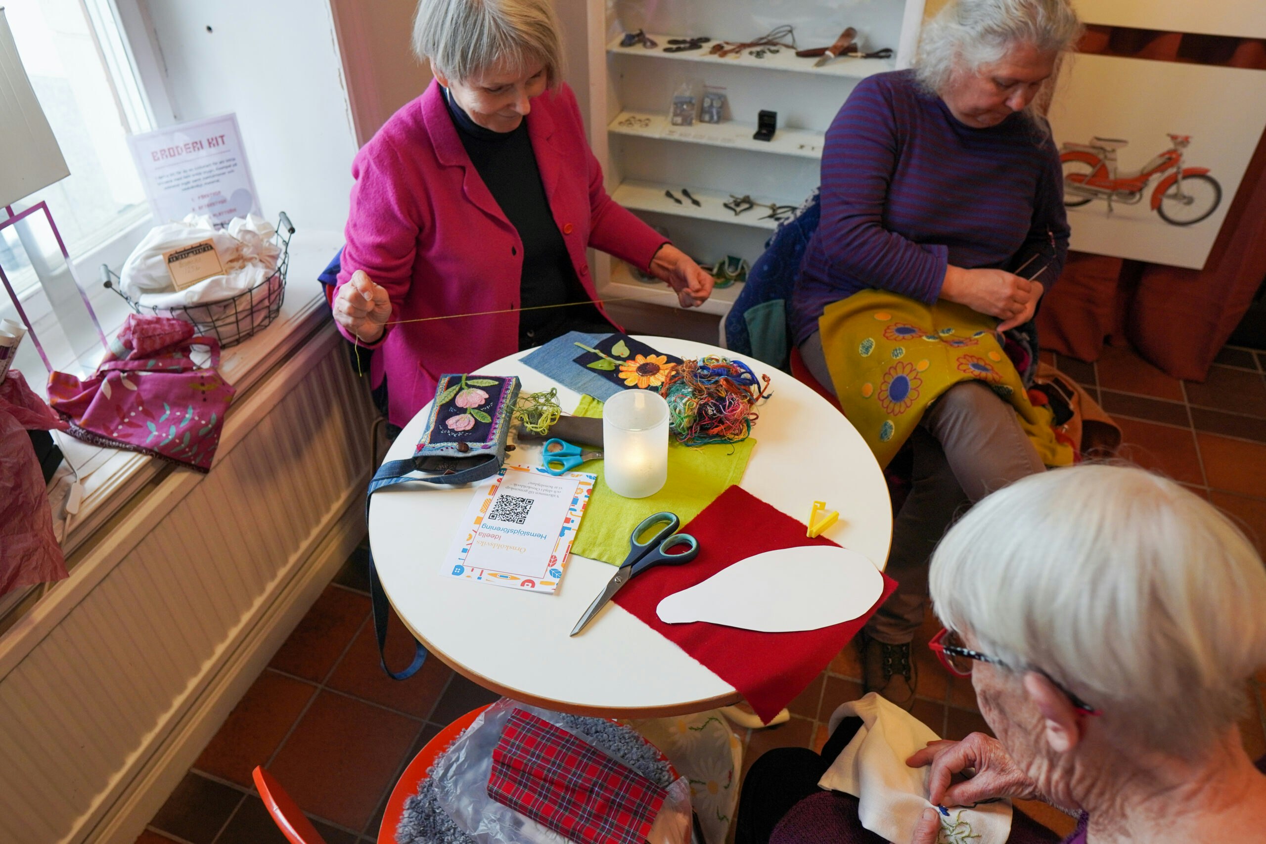 en grupp äldre kvinnor som sitter runt ett bord.