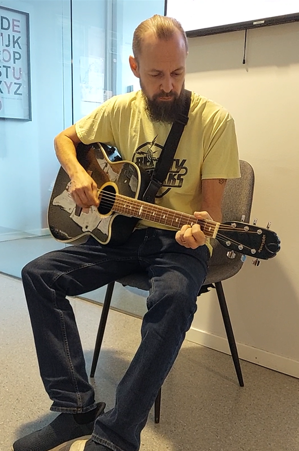 En man som spelar gitarr